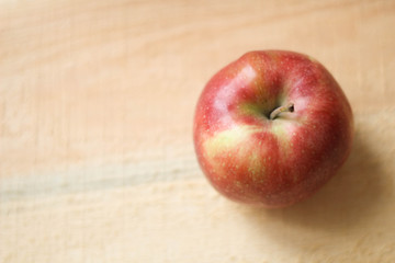 Naklejka na ściany i meble Single red apple on wooden background 