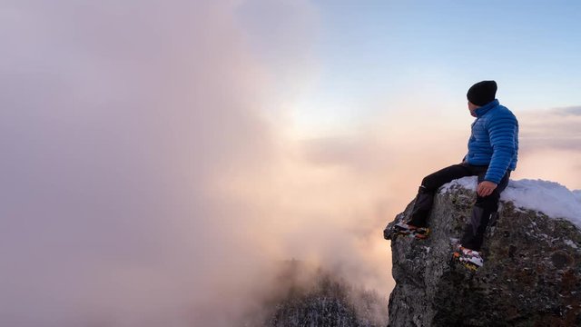 Cinemagraph of Adventurous man on edge of a cliff enjoying the beautiful mountain scenery. Taken in St Mark's Peak, North of Vancouver, British Columbia, Canada. Still Image Continuous Animation