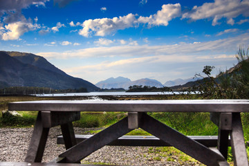 Fototapeta premium Wooden bench with scenic view of Loch Leven. Glencoe, Scotland, UK