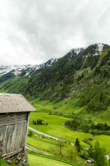 eine Berghütte aus Holz, im Hintergrund Berge