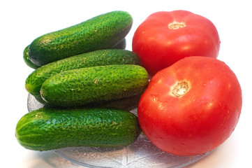 Cucumbers with tomatoes in a plate on a white background