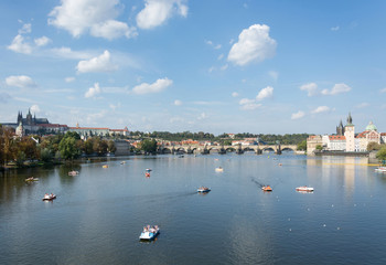 Fototapeta na wymiar Panoramic view of Vltava river, Prague castle, Charles bridge and colorful rooftops of New Town on a bright summer day, in Prague, Czech Republic