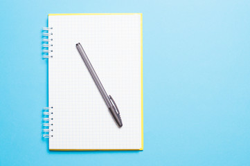 notebook with black pen on blue background