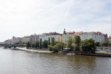 Obraz premium Waterfront panorama of Vltava river, colorful rooftops of New Town buildings on a bright summer day, in Prague, Czech Republic