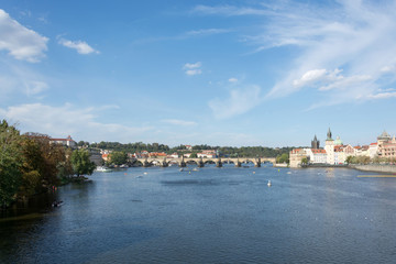 Fototapeta na wymiar Panoramic view of Vltava river and Charles bridge on a bright summer day, in Prague, Czech Republic