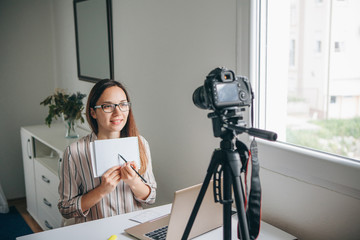 Girl blogger records video for their subscribers. Infobusiness or information business or hobby or...