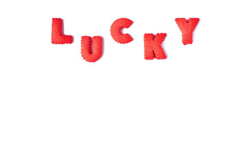 The word LUCKY spelled with red colored alphabet shaped biscuits on white background