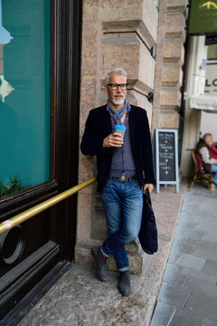 Mature man with reusable bamboo cup standing in the city