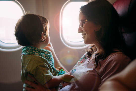 Happy mother and little daughter on airplane