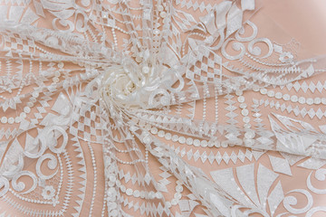 a background image of ivory-colored lace cloth. White lace on beige background.