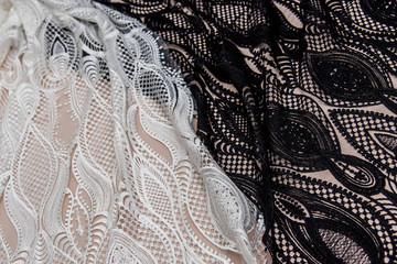 a background image of ivory-colored lace cloth. White and black lace on beige background.