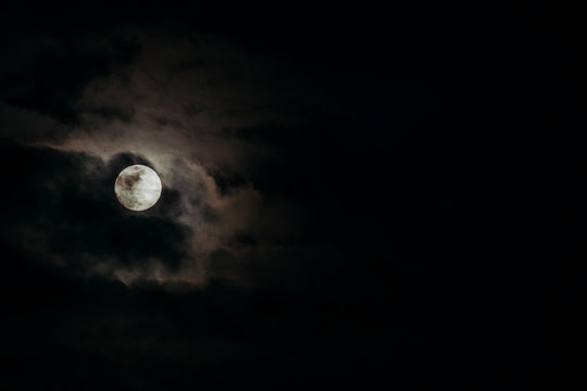 Full moon and dark clouds passing by