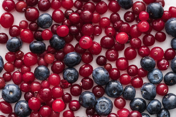 top view of red, fresh and ripe cranberries and whole blueberries