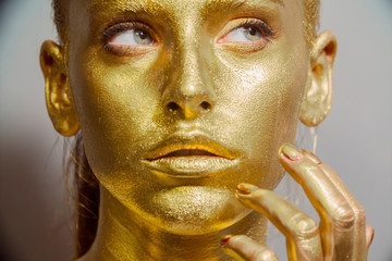 close up portrait girl with gold face makeup