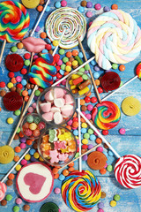 candies with jelly and sugar. colorful array of different childs sweets and treats on blue