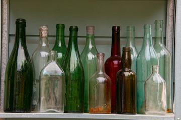 collection of old empty vintage bottles on shelf