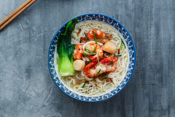Traditinoal seafood soup bee hoon with chicken broth in a bowl