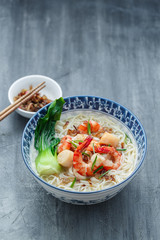 Traditional seafood soup bee hoon with chicken broth in a bowl