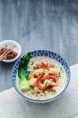 Hawker food bee hoon soup in traditional bowl, copy space