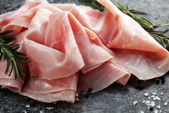 Sliced ham on wooden background. Fresh prosciutto cotto. Pork ham sliced.