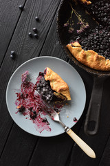 Healthy homemade pastry. Delicious crusty blueberry galette being eaten on black background