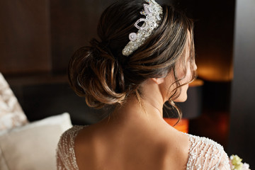 Wedding hairstyle with jewelry - fashionable brunette model young woman in a lace dress and with a...