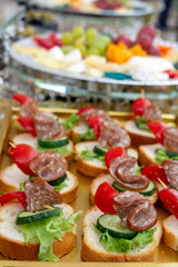 Large selection of food with cold snacks, salads, cold meats, cheese and jam served. Variety of tasty delicious snacks on the table. Wedding reception