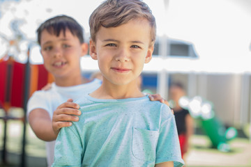 Portrait of smiling boy with friends on playground in kindergarten
