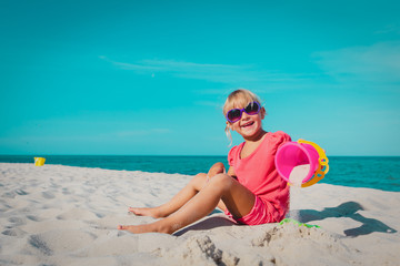 cute little girl play with sand on beach