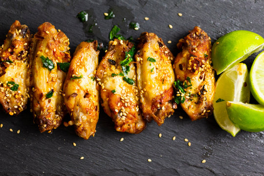 Spicy chicken wings with lime on slate