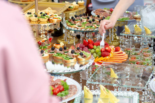 Large selection of food with cold snacks, meat and salads, fruit, cold meats, cheese and jam served. Variety of tasty delicious snacks on the table.