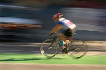 Fototapeta na wymiar Urban Cyclist Blur. A cyclist using a designated bike lane in downtown Vancouver.