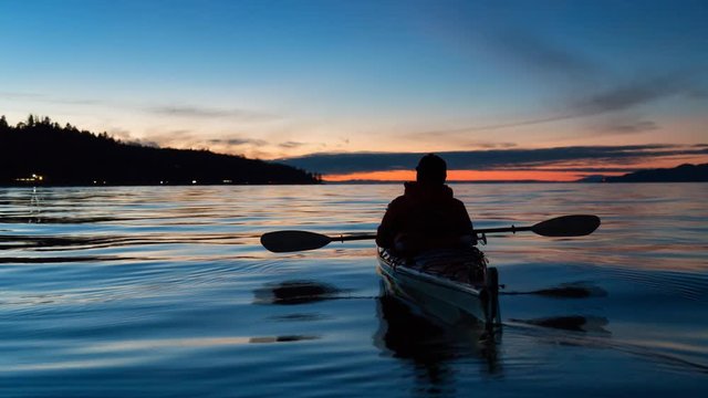Cinemagraph of a Man Kayaking on a sea kayak during a vibrant sunset. Taken near Jericho Beach, Vancouver, British Columbia, Canada. Still Image Continuous Animation