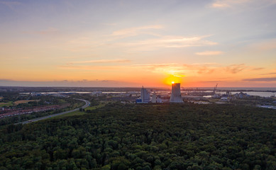 sunset over the city - aerial view of a power plant in the forest
