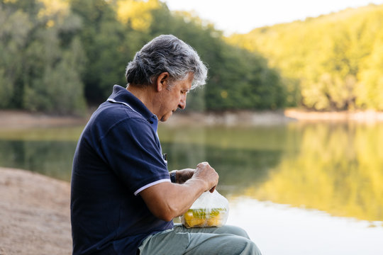 Side view of man preparing to eat fruit in the forest