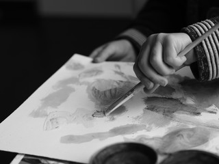 A child paints a picture with a brush and watercolor, blackandwhite picture part 2