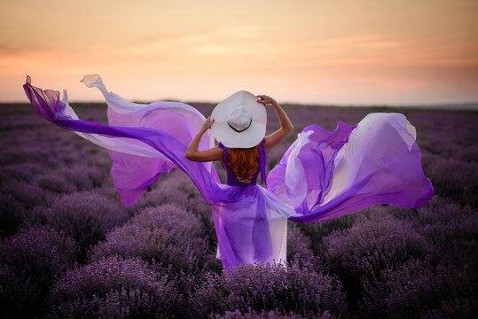 Young Woman In Luxurious Purple Dress Standing In Lavender Field, Rear View