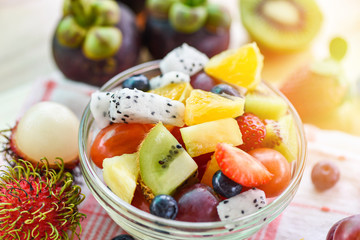 Fruit salad bowl fresh summer fruits and vegetables healthy organic food strawberries orange kiwi blueberries dragon fruit tropical grape pineapple tomato lemon mangosteen rambutan