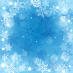 Fototapeta na wymiar Christmas blurred background of complex defocused big and small falling snowflakes in light blue colors with bokeh effect