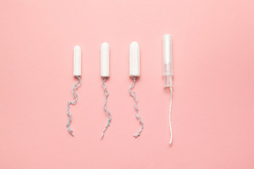Unpacked different sizes and types tampons on a soft pink background. Modern female intimate gynecological hygiene. Eco zero waste concept. Copy spase place for text. Flat lay