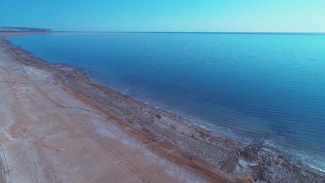 Sea foam at the beach of the Aral Sea near Aktumsuk cape at sunset in Karakalpakstan, Uzbekistan.