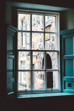 View through old window frame with aged stone building behind in soft daylight, Scotland