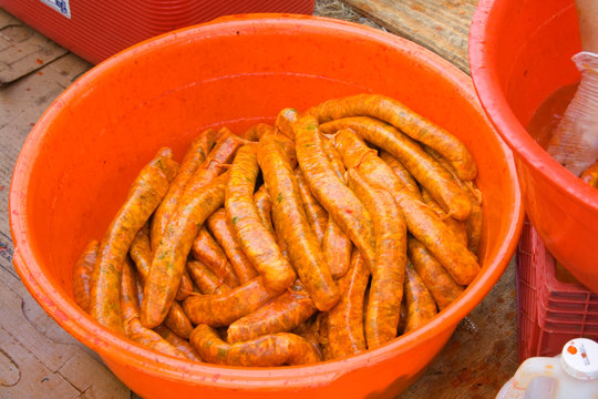 Sausages ready to be cooked in an orange bowl. Hmong ethnic cuisine. Hmong Sports Festival McMurray Field St Paul Minnesota MN USA