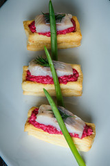 top view macro snacks with herring pieces and green onion
