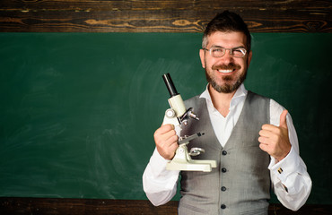 Teacher in classroom at elementary school. Teacher giving lesson to students. Confident male...