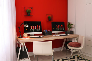 Modern workplace with large desk and computers in room. Stylish interior