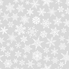Christmas seamless pattern of complex small snowflakes in white colors on gray background