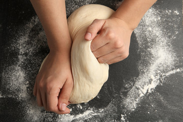 Female baker preparing bread dough at grey table, top view