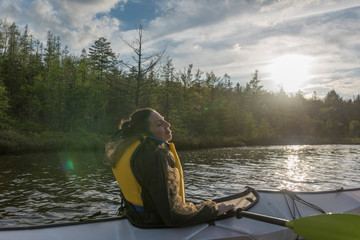 a woman in a white kayak soaks in the sun during a cool spring day