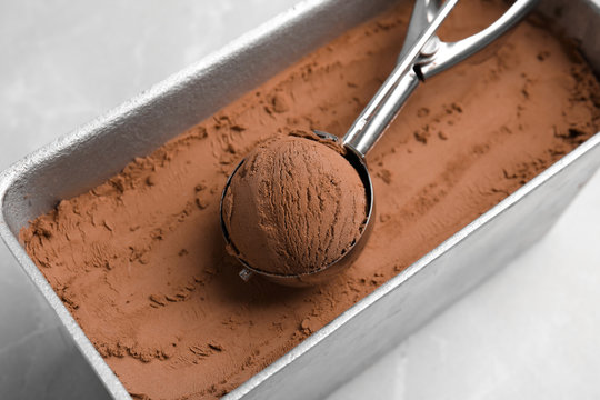 Scoop Of Chocolate Ice Cream In Container On Table, Closeup